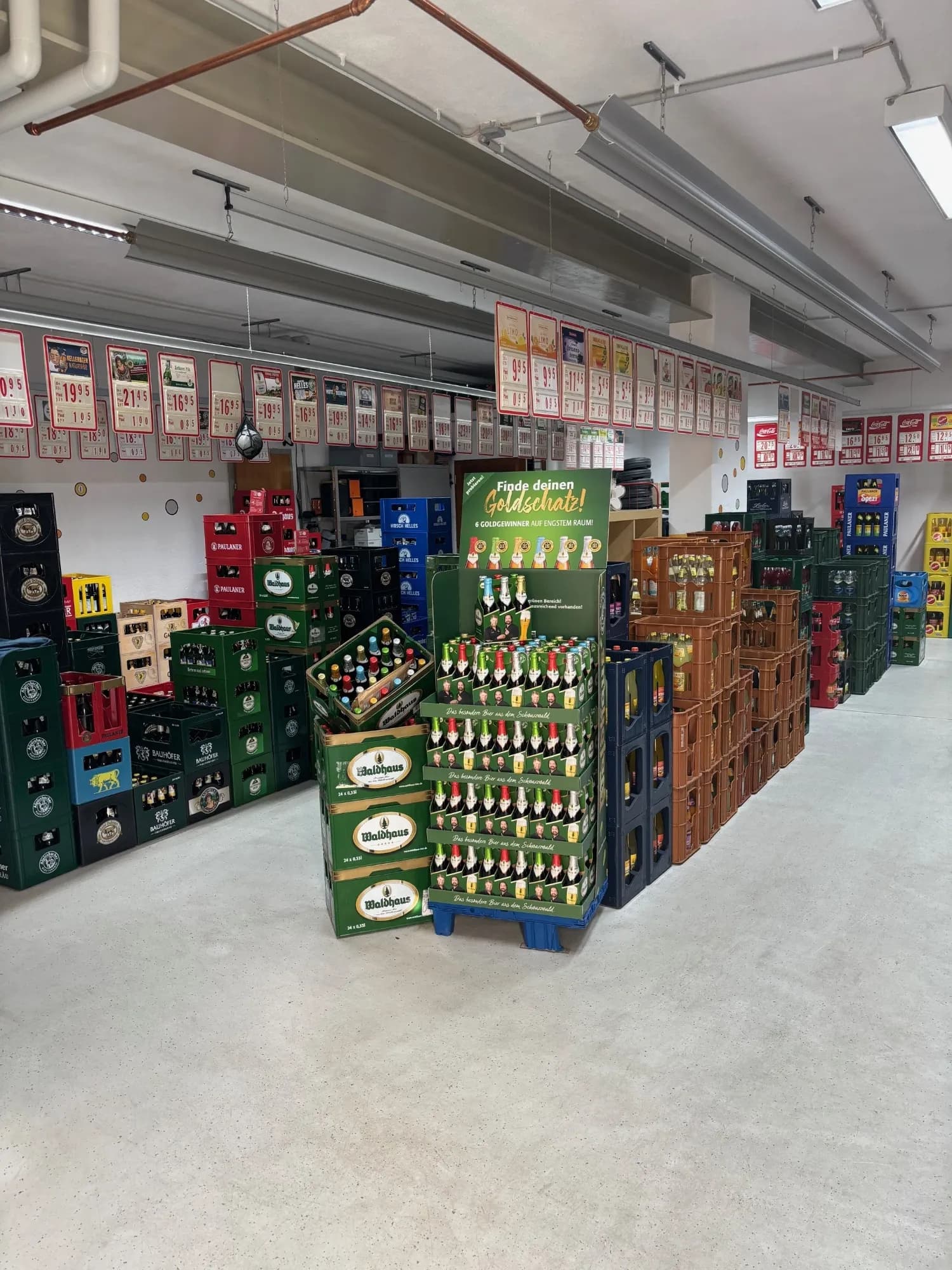 Lager mit verschiedenen Getränkekästen in einem großen Raum.