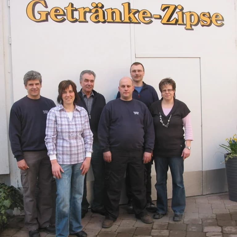 Sechsköpfiges Team in dunklen Arbeitspullovern vor dem Schriftzug Getränke-Zipse am Geschäft in Endingen.