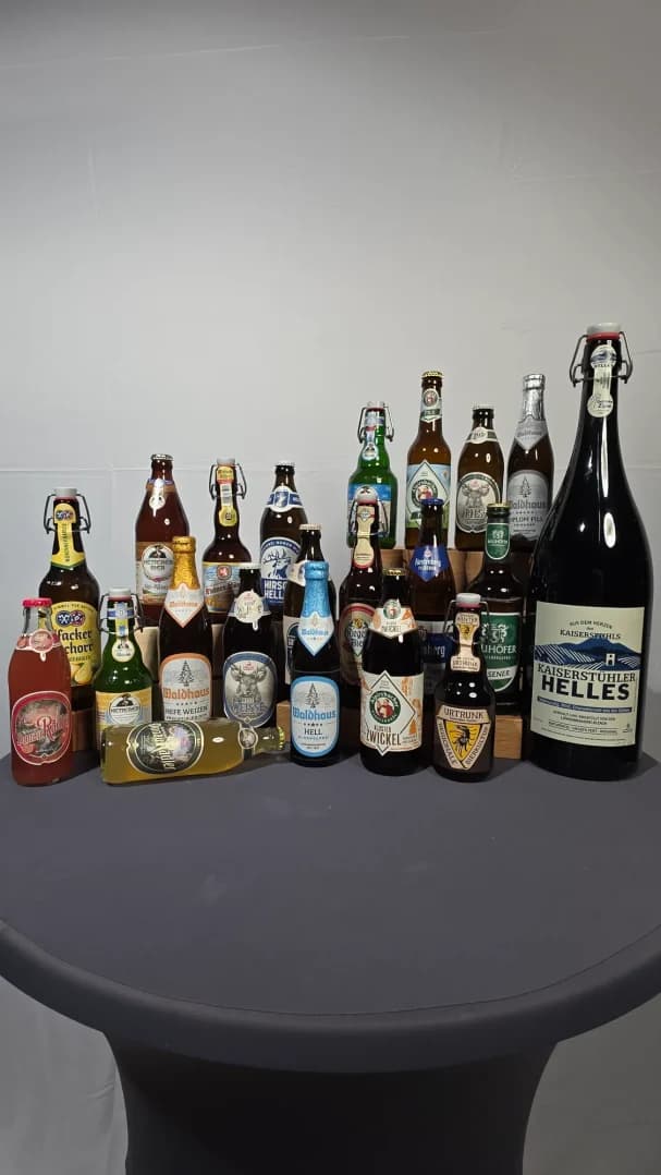 Verschiedene Bierflaschen auf einem Tisch, einschließlich einer großen Flasche.