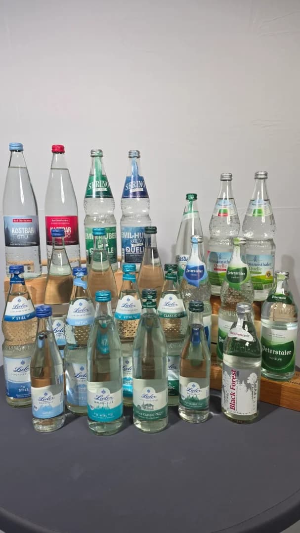 Verschiedene Flaschen mit Mineralwasser auf einem Tisch angeordnet.
