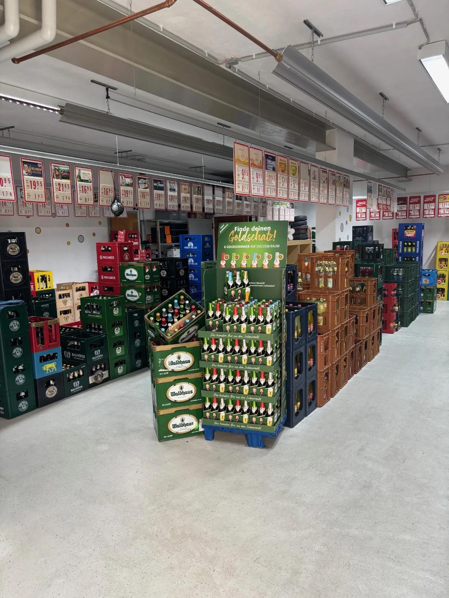 Lager mit verschiedenen Getränkekästen in einem großen Raum.